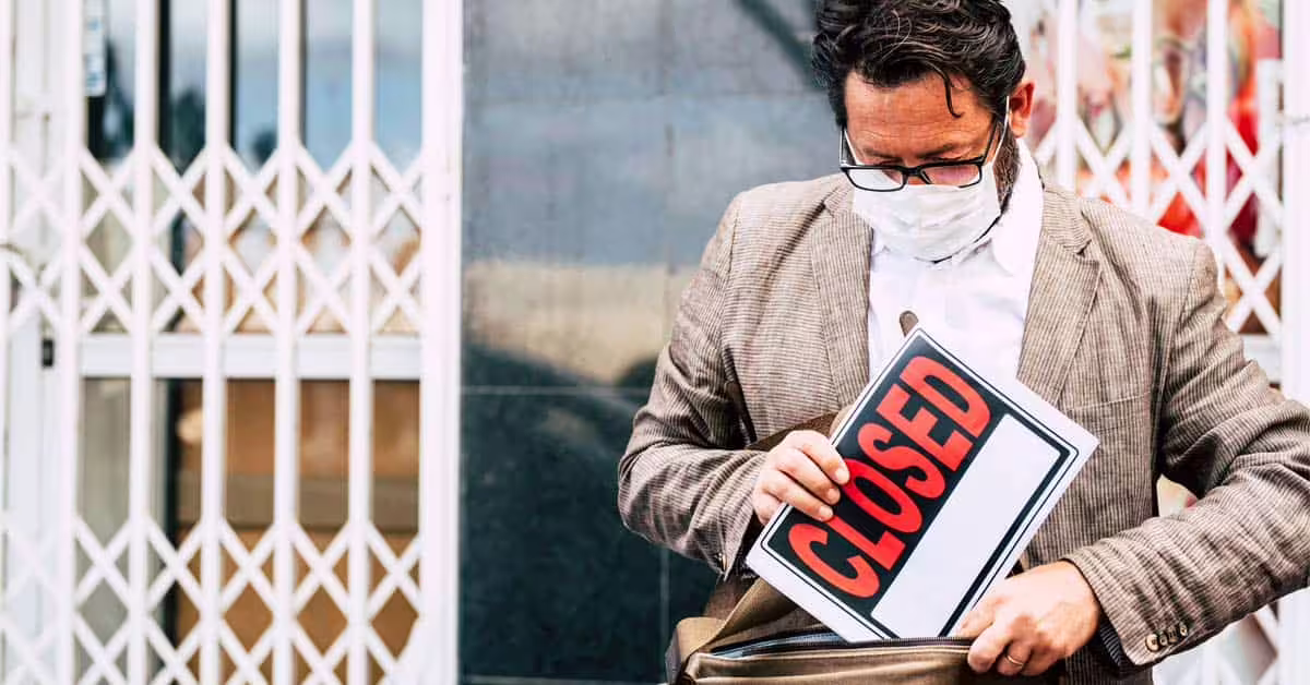 Failed business store man with on sale sign outside his store