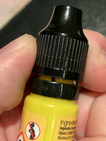 Unopened e-liquid bottle with intact tamper-evident seal